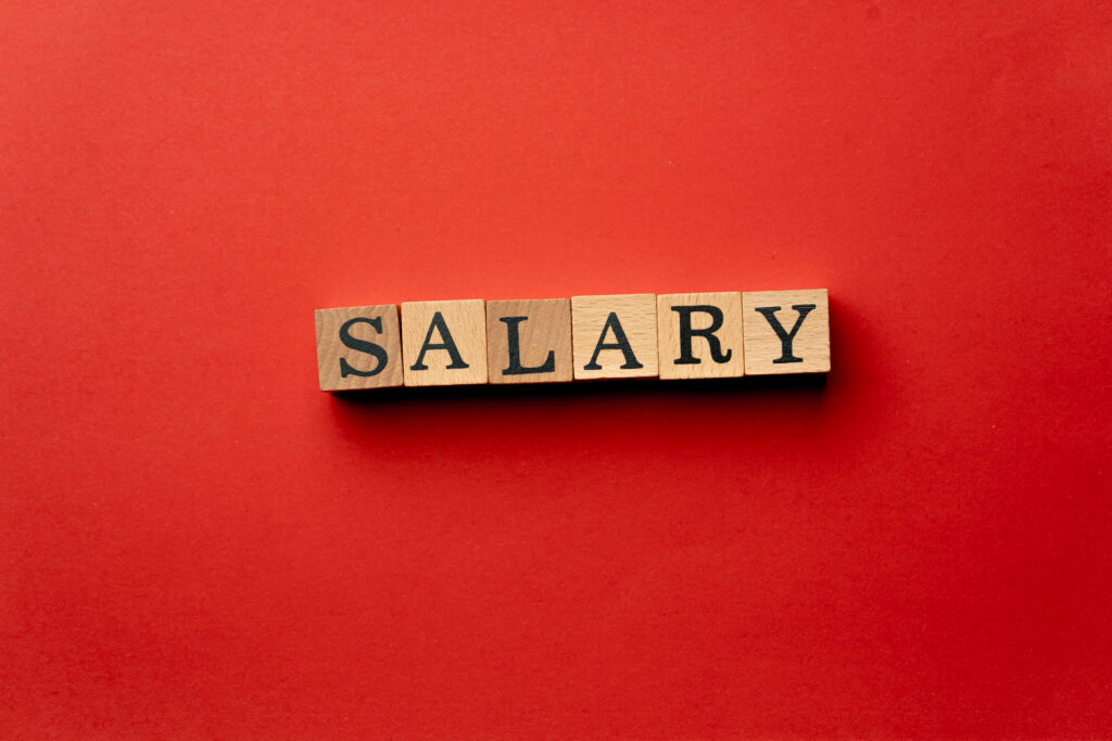 "Wooden letter blocks spelling the word salary on a red background – representing 2025 salary threshold changes for sponsored workers in the UK."
