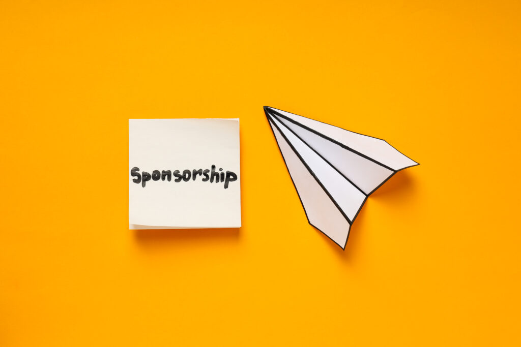 Sponsorship concept with paper plane and note on bright yellow background.