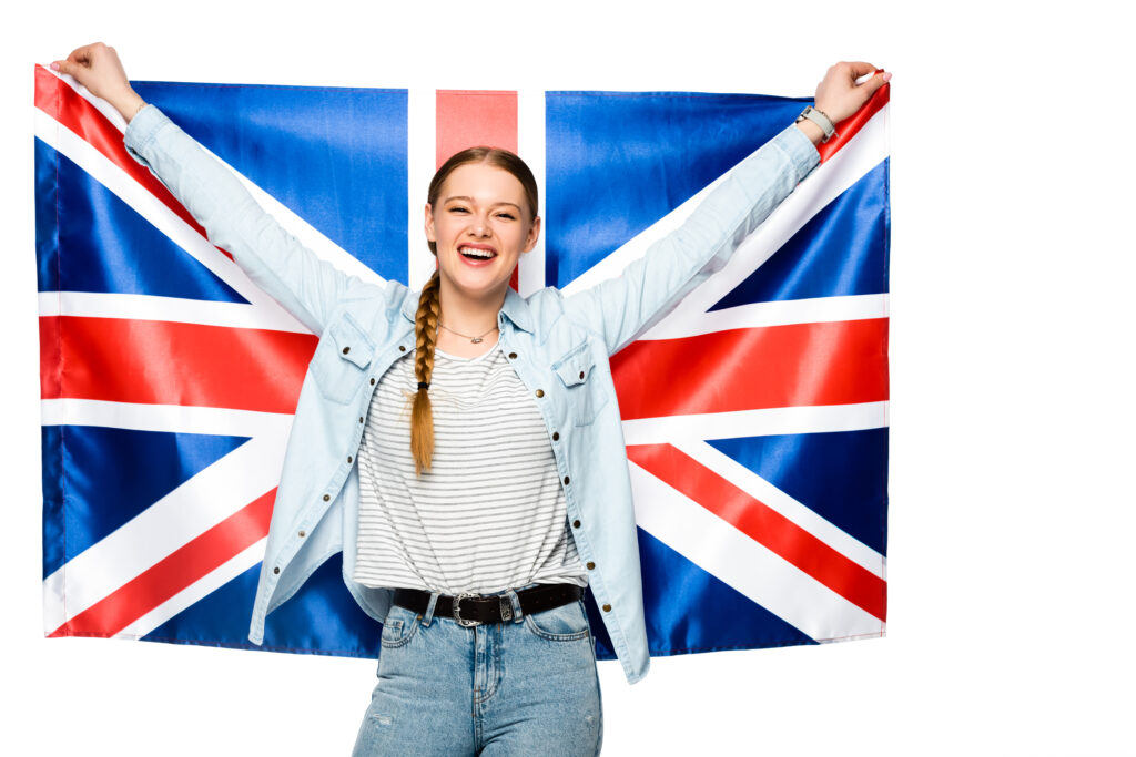 Smiling young woman holding the UK flag, symbolising opportunities under the Skilled Worker visa in 2025.