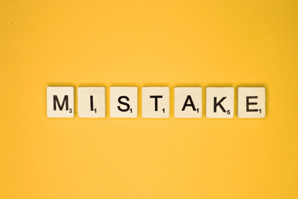 Scrabble tiles spelling the word “Mistake” on a yellow background, representing common errors in sponsor licence applications.