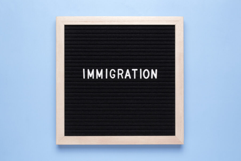 A professional office setting with HR and management staff reviewing immigration compliance documents, representing the impact of the 2025 Immigration White Paper on employer responsibilities in the UK.