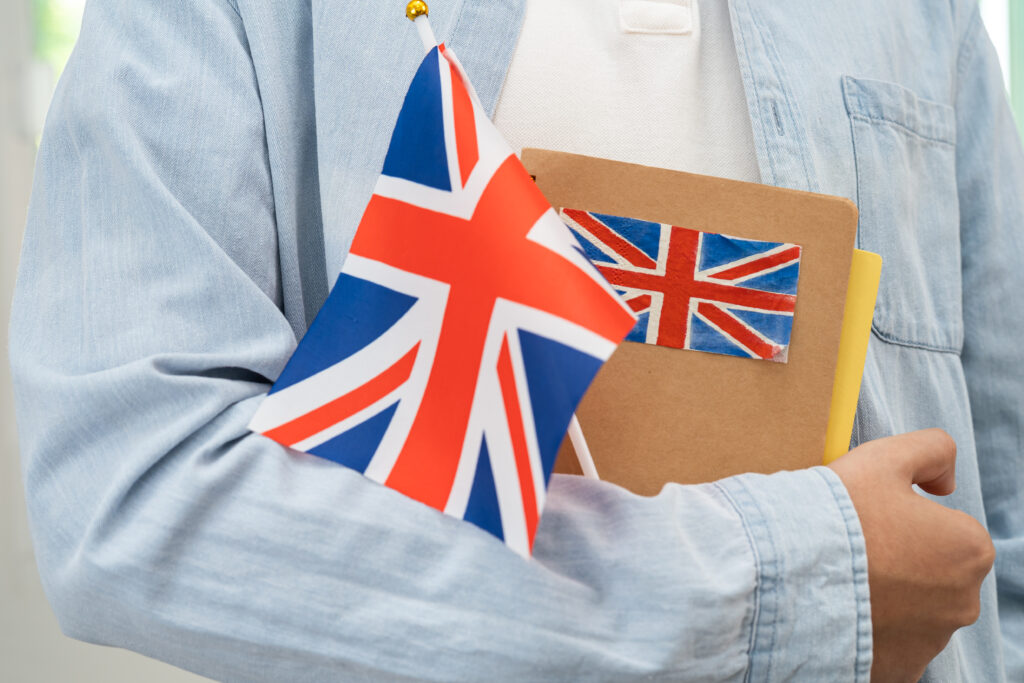 Illustration of a senior employee overseeing UK visa sponsorship duties on a laptop, representing the Authorising Officer role in 2025.