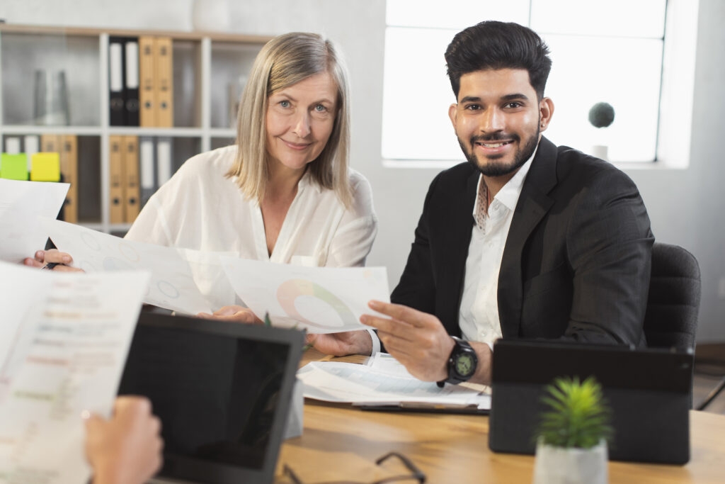 Conceptual image of a UK business owner weighing scales with “costs” on one side and “benefits” on the other, symbolising the decision of whether a sponsor licence is worth it in 2025.