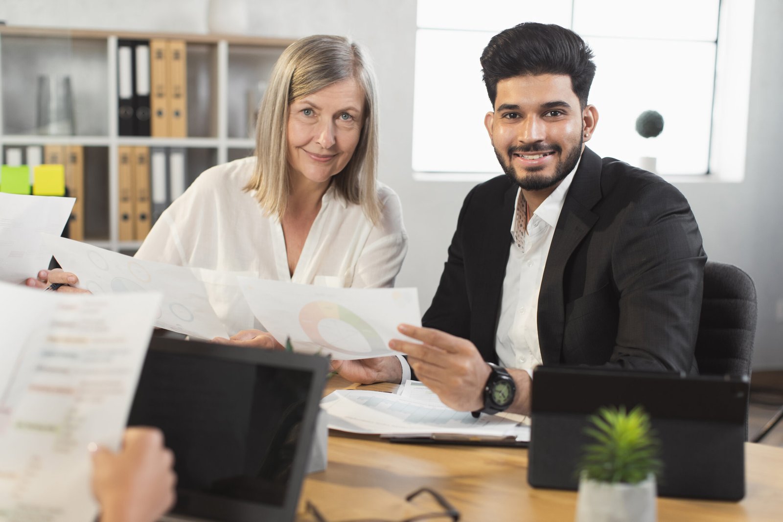 Conceptual image of a UK business owner weighing scales with “costs” on one side and “benefits” on the other, symbolising the decision of whether a sponsor licence is worth it in 2025.