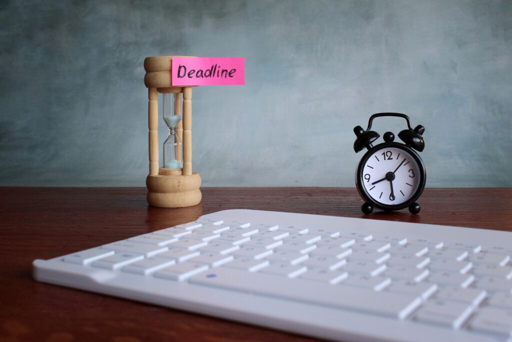 A professional reviewing sponsor licence reporting deadlines on a laptop, with SMS dashboards and compliance tables visible, illustrating UKVI reporting responsibilities.